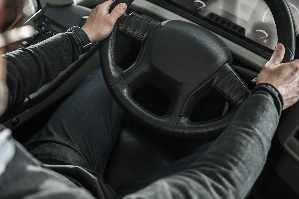 man holding truck steering wheel